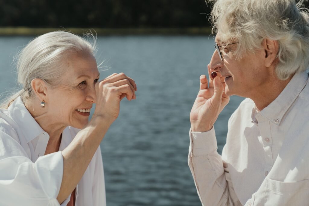 Two older women talking, one pointing to her ear