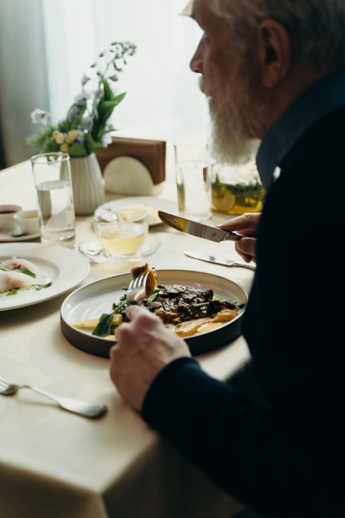 Elderly parent not eating, sitting at the table with a meal