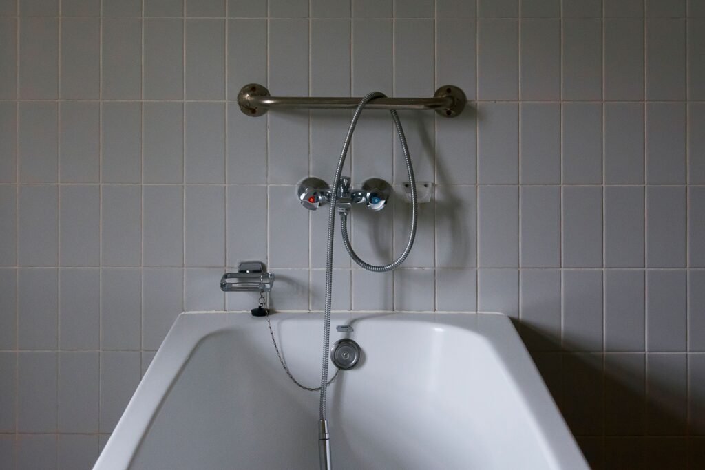 Bathtub with a grab bar and handheld shower