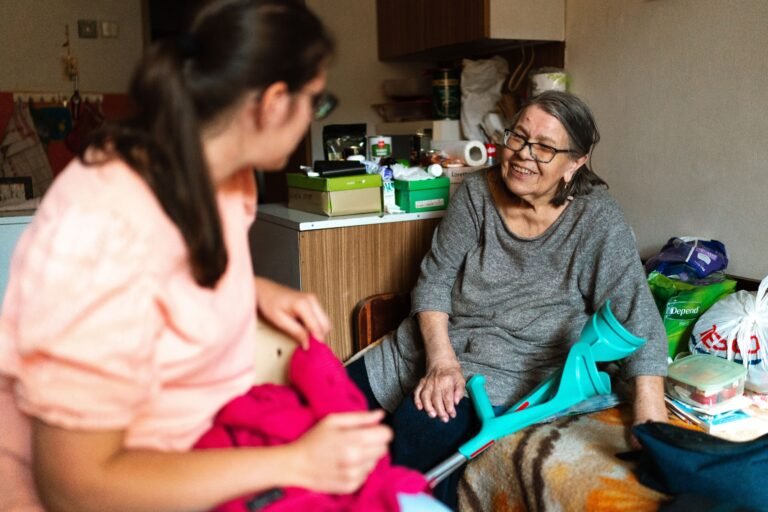 Adult daughter sitting with her older mother at home