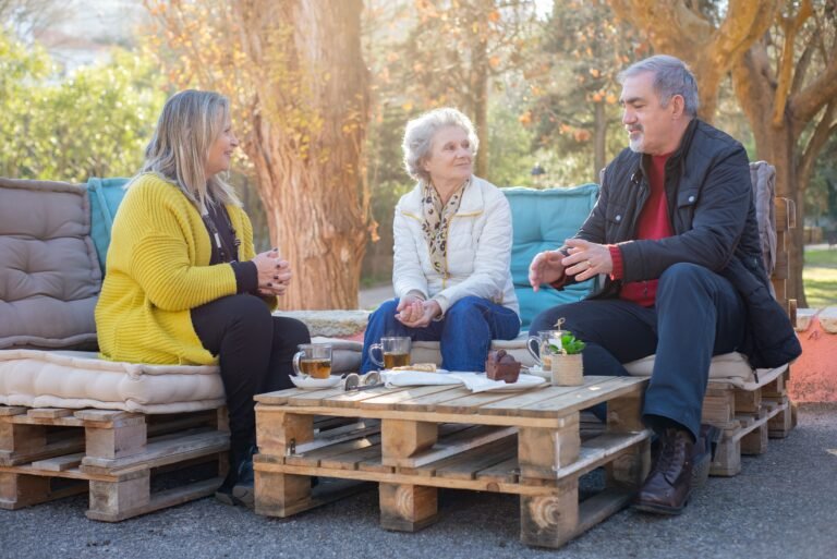 Adult siblings and their aging parents talking together outdoors