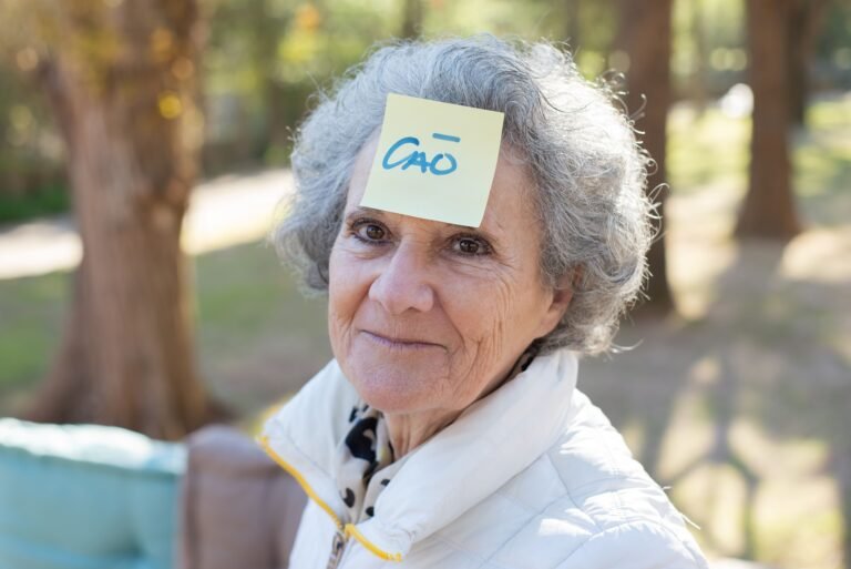 Smiling older woman with a reminder note stuck on her forehead
