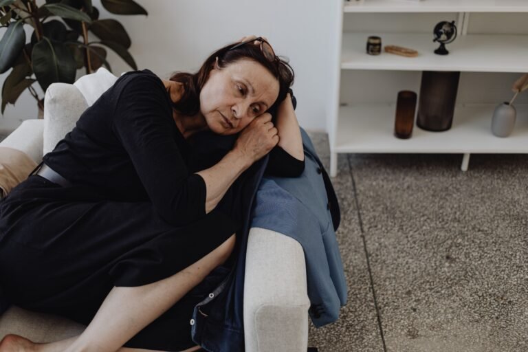 Tired caregiver resting her head on a sofa