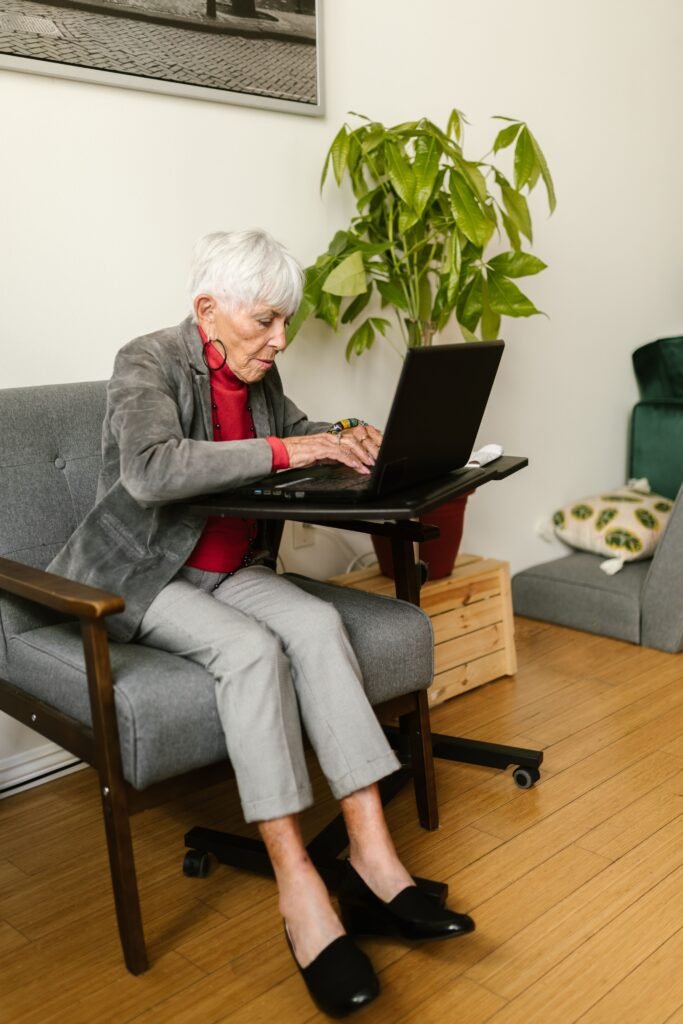 Older woman using a laptop in a comfortable armchair