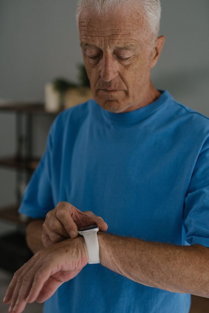 Older man checking a wearable device on his wrist